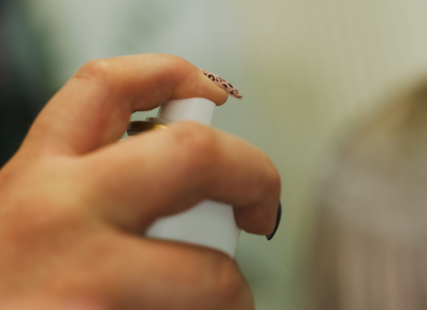 Hand sprüht Pflegespray auf das Haar